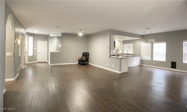 unfurnished living room featuring dark hardwood / wood-style floors and ceiling fan