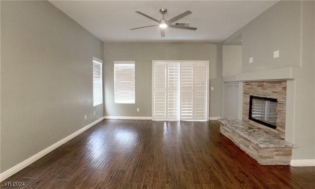 unfurnished living room with a fireplace, dark hardwood / wood-style flooring, and ceiling fan