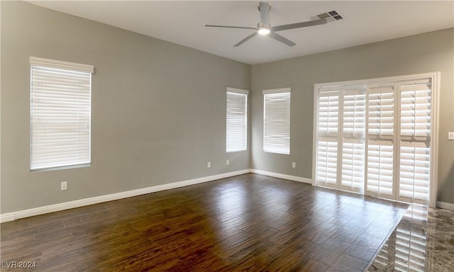 spare room with ceiling fan, a healthy amount of sunlight, and dark hardwood / wood-style floors