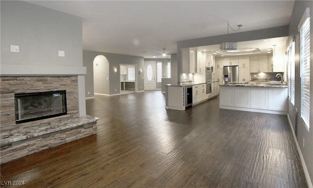 kitchen featuring pendant lighting, sink, appliances with stainless steel finishes, dark hardwood / wood-style flooring, and white cabinetry