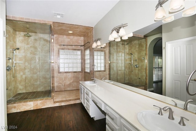 bathroom with hardwood / wood-style floors, vanity, vaulted ceiling, and walk in shower