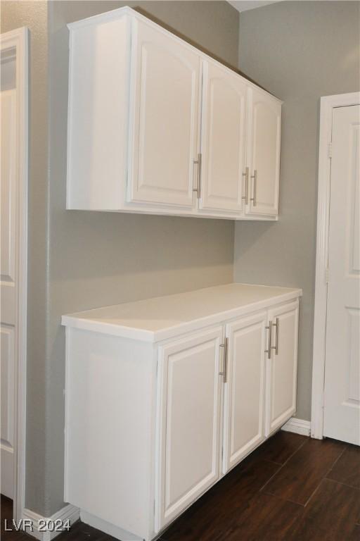 clothes washing area with dark wood-type flooring