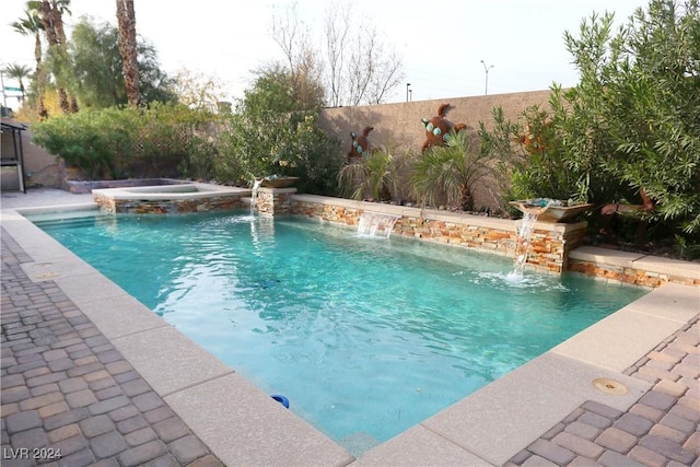 view of swimming pool with pool water feature and an in ground hot tub