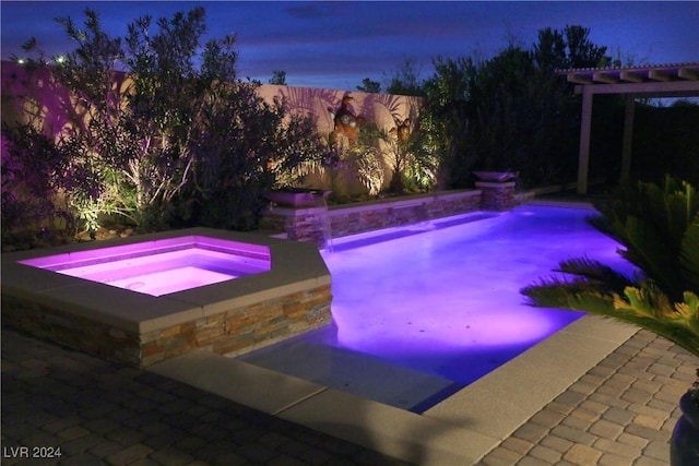 pool at dusk with a pergola and an in ground hot tub