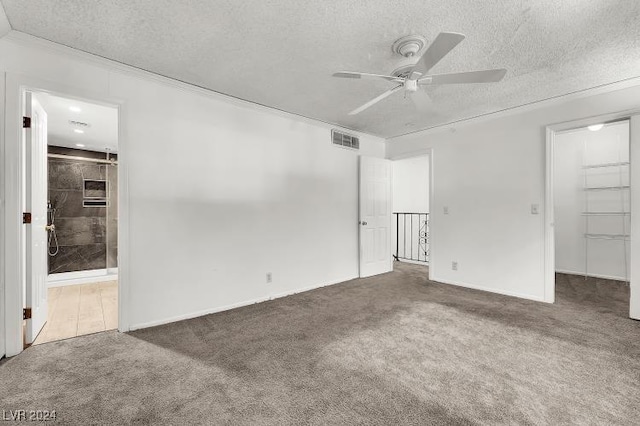 carpeted empty room with ceiling fan and a textured ceiling