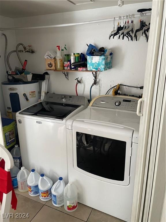 laundry room with tile patterned floors, electric water heater, and washer and dryer