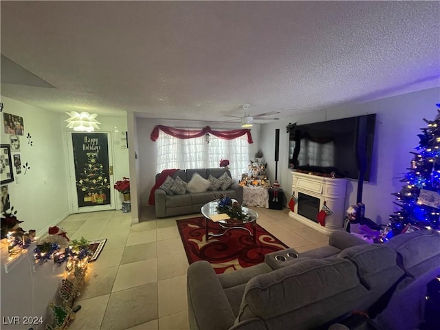 tiled living room featuring ceiling fan and a textured ceiling