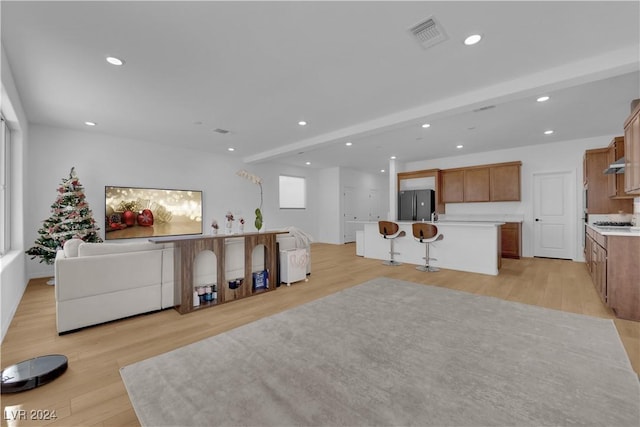 living room with beamed ceiling and light wood-type flooring