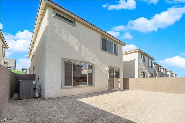 back of property with a patio and central AC