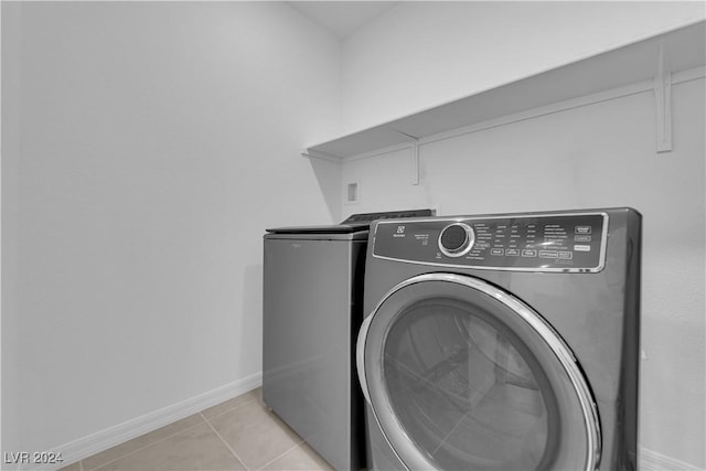 washroom featuring washing machine and dryer and light tile patterned floors