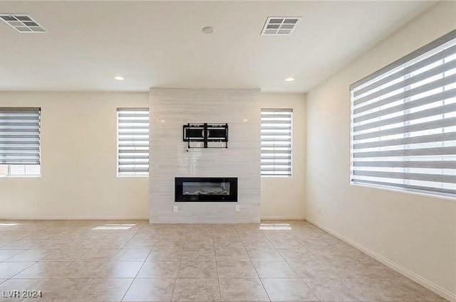 unfurnished living room featuring light tile patterned floors and a fireplace