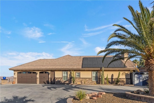 single story home with solar panels and a garage