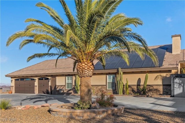 view of front of home featuring a garage and solar panels