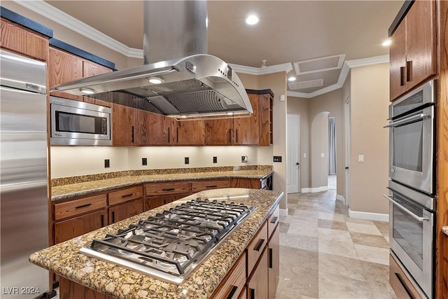 kitchen with island exhaust hood, ornamental molding, stainless steel appliances, stone countertops, and a kitchen island