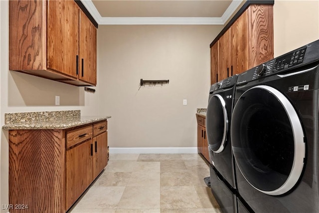 laundry room with cabinets, crown molding, and washing machine and clothes dryer