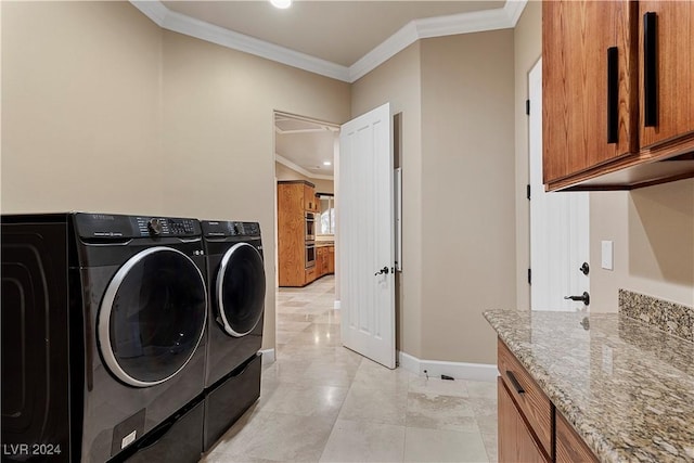 washroom with washer and clothes dryer, cabinets, and ornamental molding