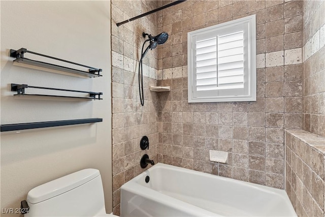 bathroom with toilet and tiled shower / bath