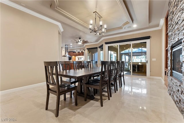 dining space featuring a tray ceiling, crown molding, and ceiling fan with notable chandelier