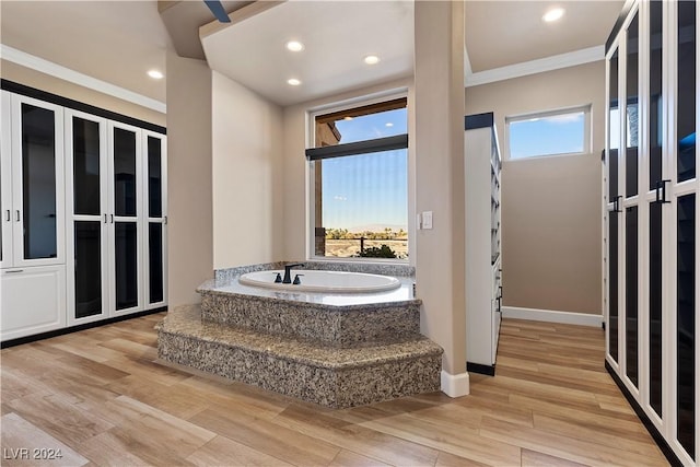 bathroom featuring crown molding, a bath, and hardwood / wood-style flooring