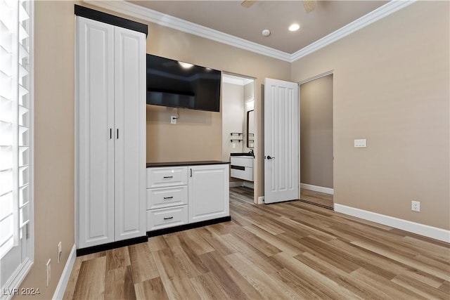 unfurnished bedroom featuring light hardwood / wood-style floors, ceiling fan, and crown molding