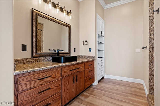 bathroom featuring hardwood / wood-style floors, vanity, and crown molding