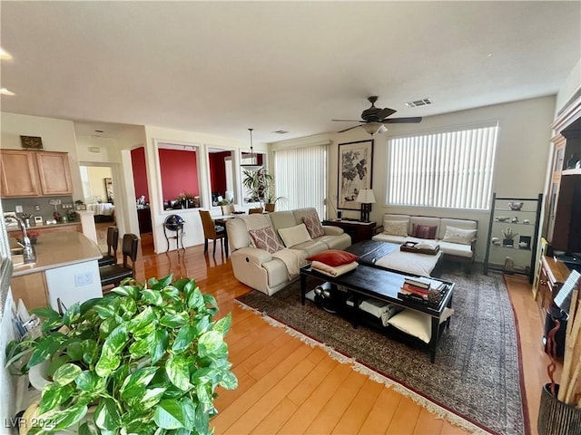 living room with ceiling fan and light wood-type flooring