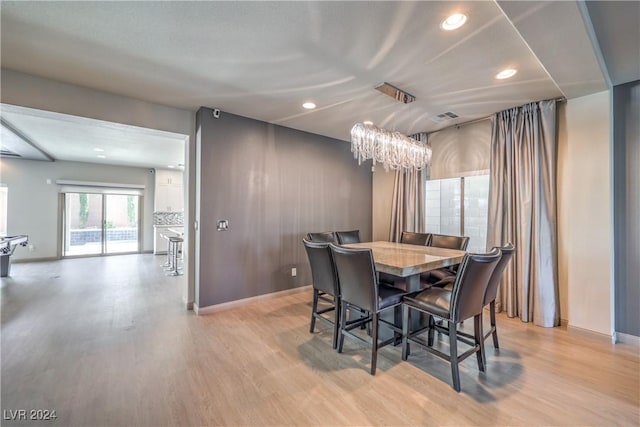 dining area featuring a notable chandelier and light wood-type flooring