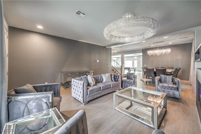 living room featuring light wood-type flooring and a notable chandelier