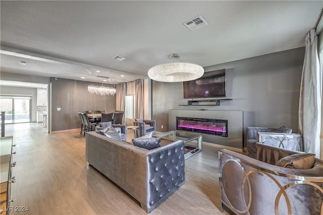 living room with a chandelier and light hardwood / wood-style floors