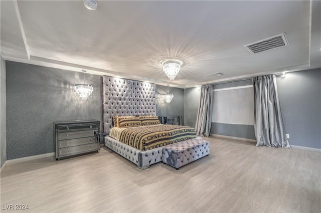 bedroom with hardwood / wood-style flooring and a chandelier