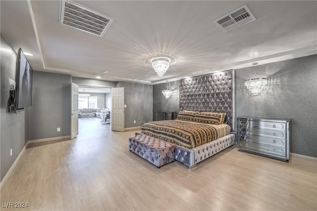 bedroom with wood-type flooring and an inviting chandelier