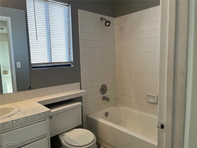 full bathroom featuring vanity, toilet, and tiled shower / bath combo