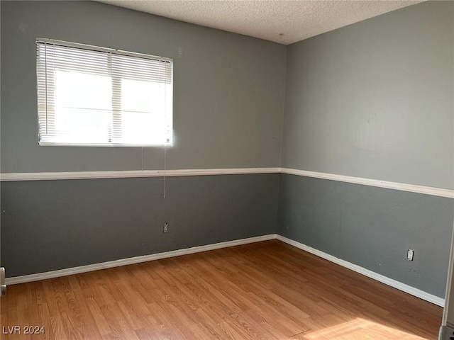 spare room with hardwood / wood-style floors and a textured ceiling