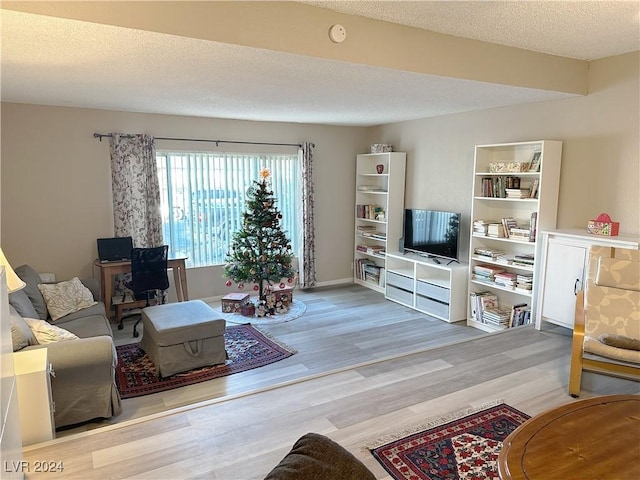 living room featuring light hardwood / wood-style flooring and a textured ceiling