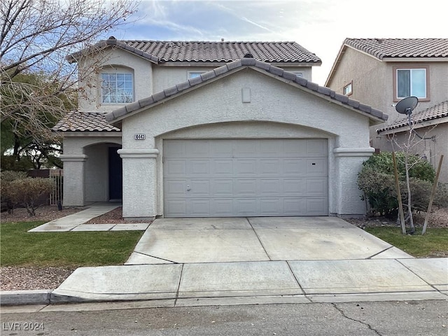 mediterranean / spanish-style home with a garage