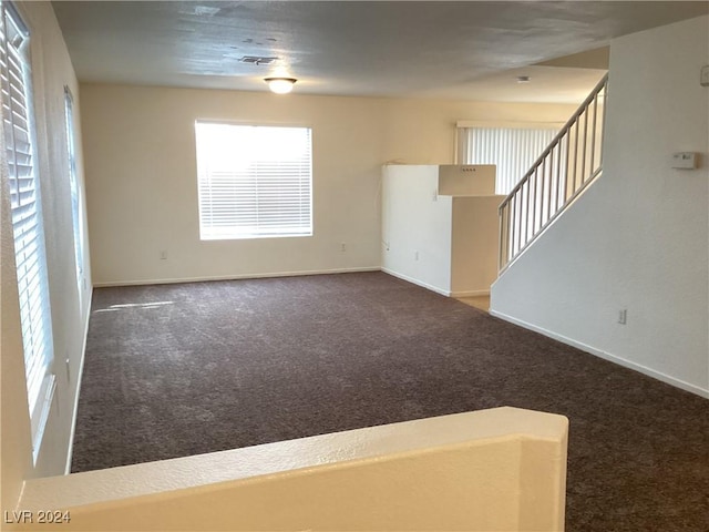 unfurnished living room featuring dark colored carpet