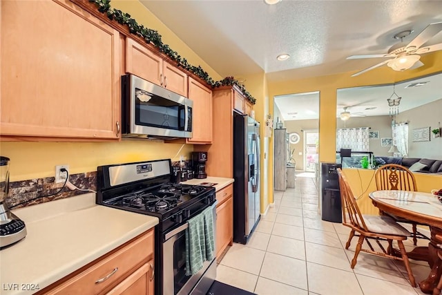 kitchen featuring a textured ceiling, light tile patterned flooring, and stainless steel appliances