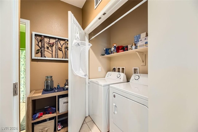 clothes washing area with light tile patterned flooring and washing machine and dryer