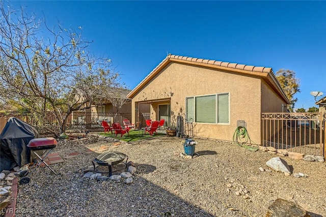 rear view of property featuring a fire pit