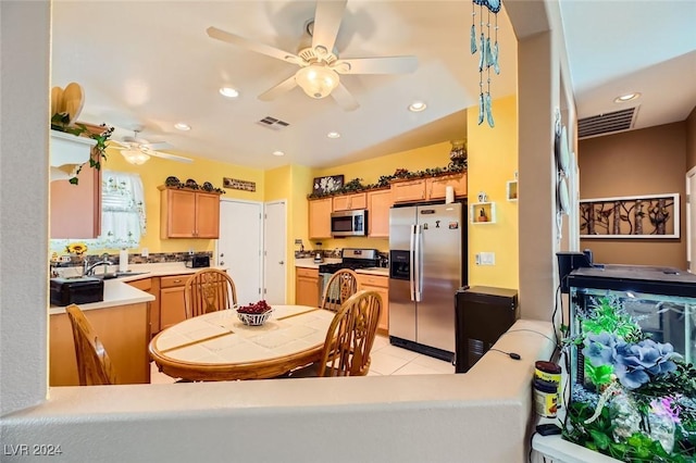 dining area featuring ceiling fan, sink, and light tile patterned flooring