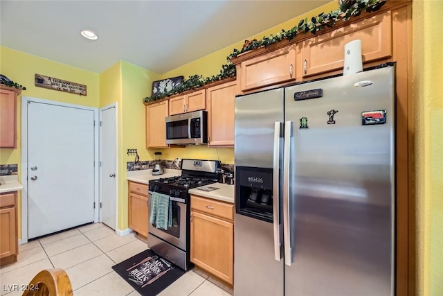 kitchen with light brown cabinets, light tile patterned flooring, and appliances with stainless steel finishes