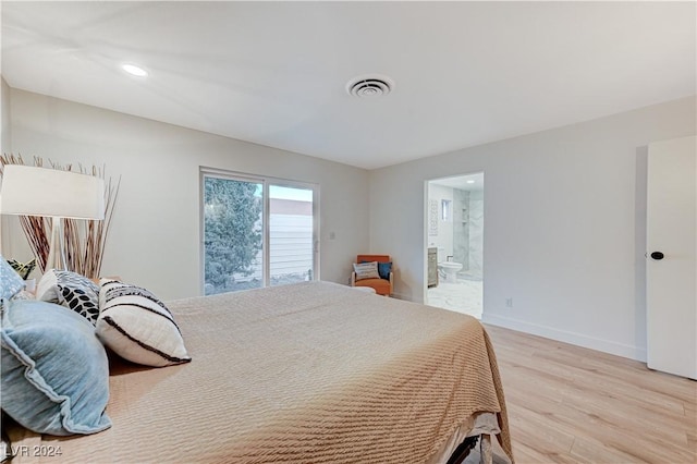 bedroom featuring light wood-type flooring and ensuite bath