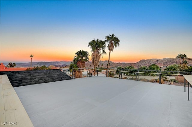 patio terrace at dusk featuring a mountain view