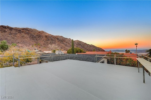 patio terrace at dusk featuring a mountain view