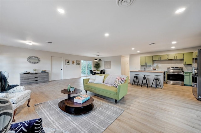 living room featuring sink and light wood-type flooring