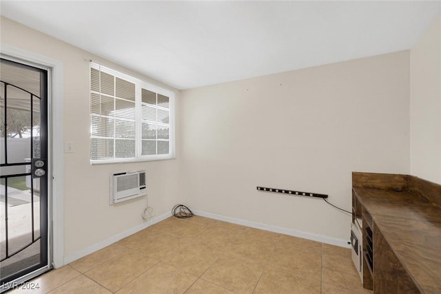 laundry room featuring a wall unit AC and light tile patterned flooring