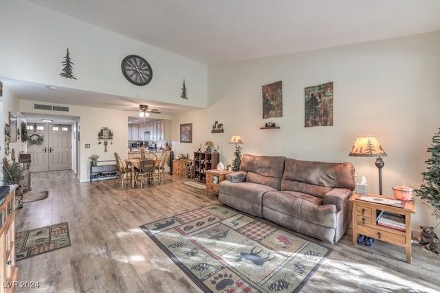 living room featuring ceiling fan, hardwood / wood-style floors, and lofted ceiling