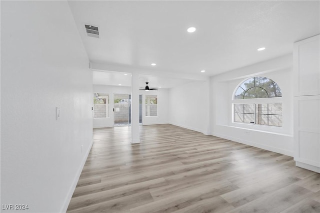 unfurnished living room featuring ceiling fan and light hardwood / wood-style flooring