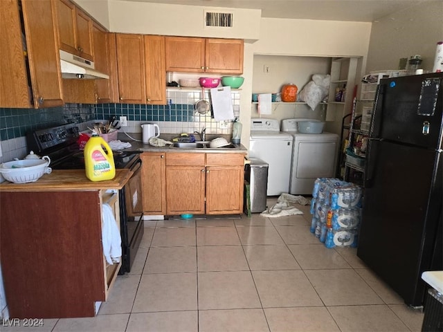 kitchen featuring black appliances, sink, decorative backsplash, separate washer and dryer, and light tile patterned floors