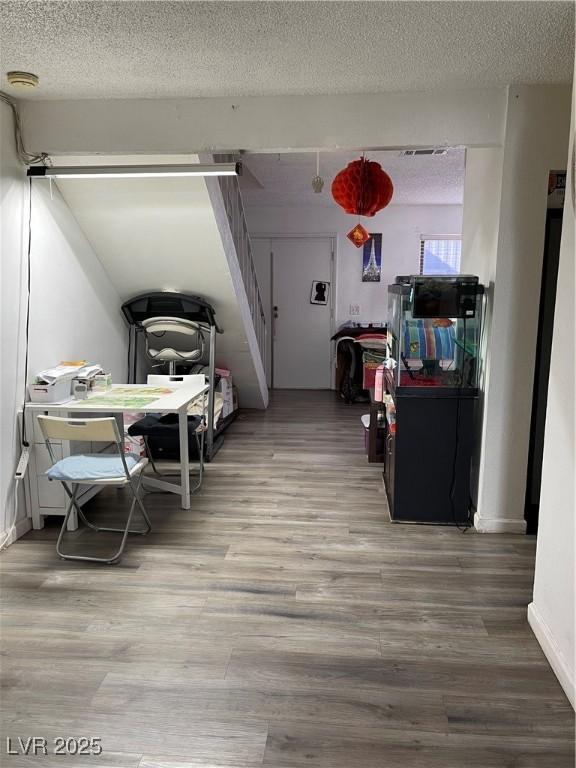 dining space with wood-type flooring and a textured ceiling